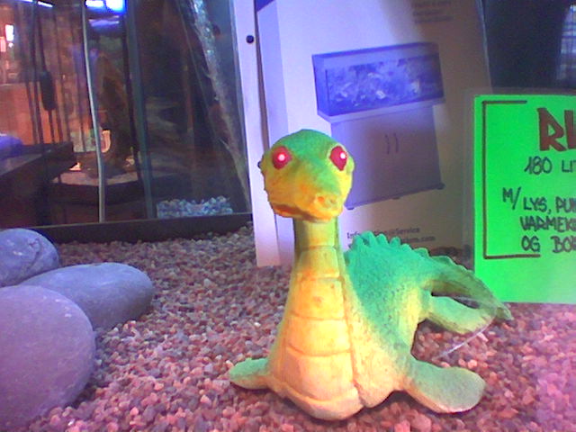 A green and yellow dinosaur with red eyes.